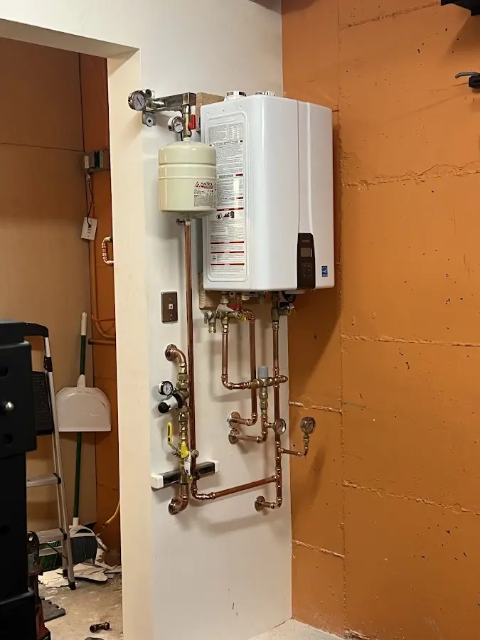 Plumbing technician inspecting water heater connections in Orangevale